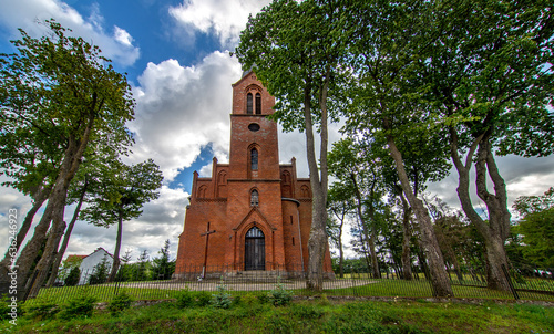 Fototapeta Naklejka Na Ścianę i Meble -  General view and close-up architectural details of the Catholic Church of St. Holy Trinity in the town of Dwawrzuty in Masuria in Poland.