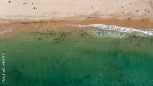 Straight down aerial photo of the beautiful town in Albufeira in Portugal showing the Praia da Oura beach with and people relaxing on vacation on the beach on a hot summers day in the summer time. photo