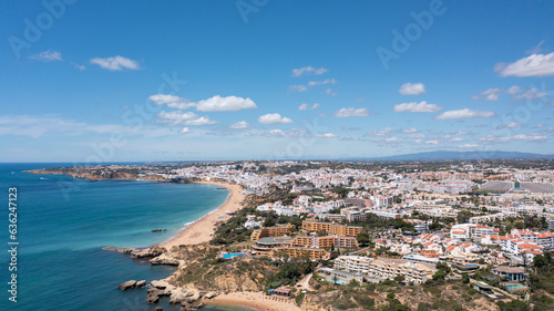 Aerial photo of the beautiful town in Albufeira in Portugal showing the Praia da Oura golden sandy beach, with hotels and apartment in the town, taken on a summers day in the summer time.