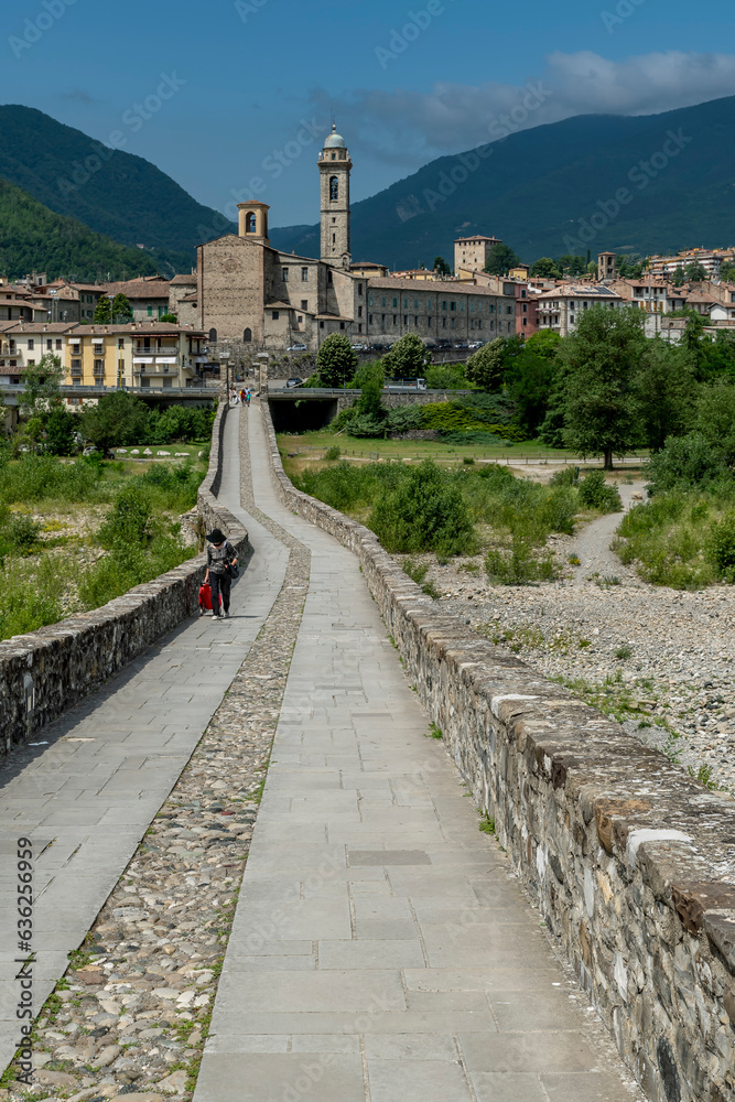 The ancient Ponte Gobbo over the Trebbia river with Bobbio in the background, Italy