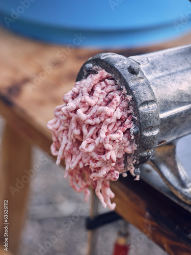 Meat grinder with mince on table in slaughterhouse