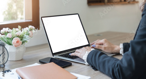 Young Asia businesswoman use laptop with blank white screen mock up display for advertising text while working at her workplace