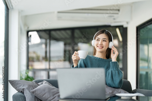 Asian teenage girls are happily listening to music from headphone, Asian girls relax by listening to music in the home