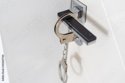 handcuffs hanging from bedroom door handle 