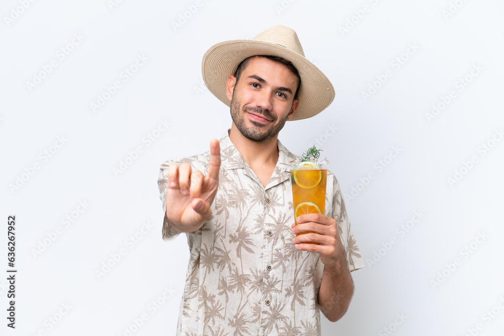 Young caucasian man holding a cocktail isolated on white background showing and lifting a finger