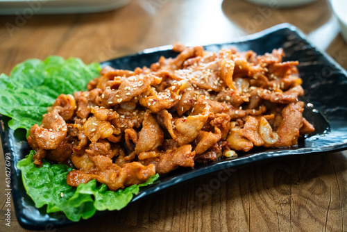 Delicious Korean cuisine jeyuk bokkeum, stir-fried pork in a plate for serving dish. photo