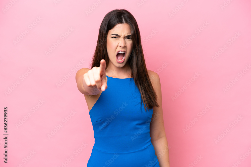 Young Brazilian woman isolated on pink background frustrated and pointing to the front Young Brazilian woman isolated on pink background frustrated and pointing to the front