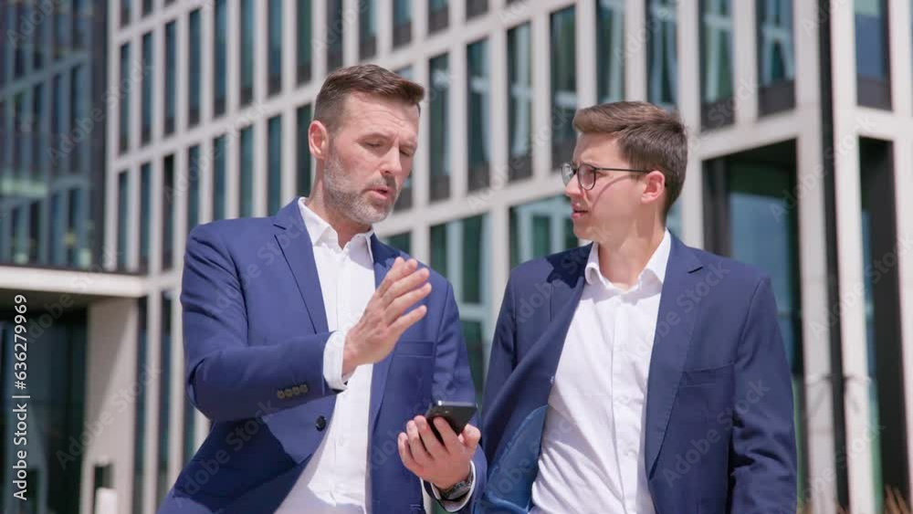 Two young business men walk and talk outdoors, half body portrait shot Two young business men walk and talk outdoors, half body portrait shot