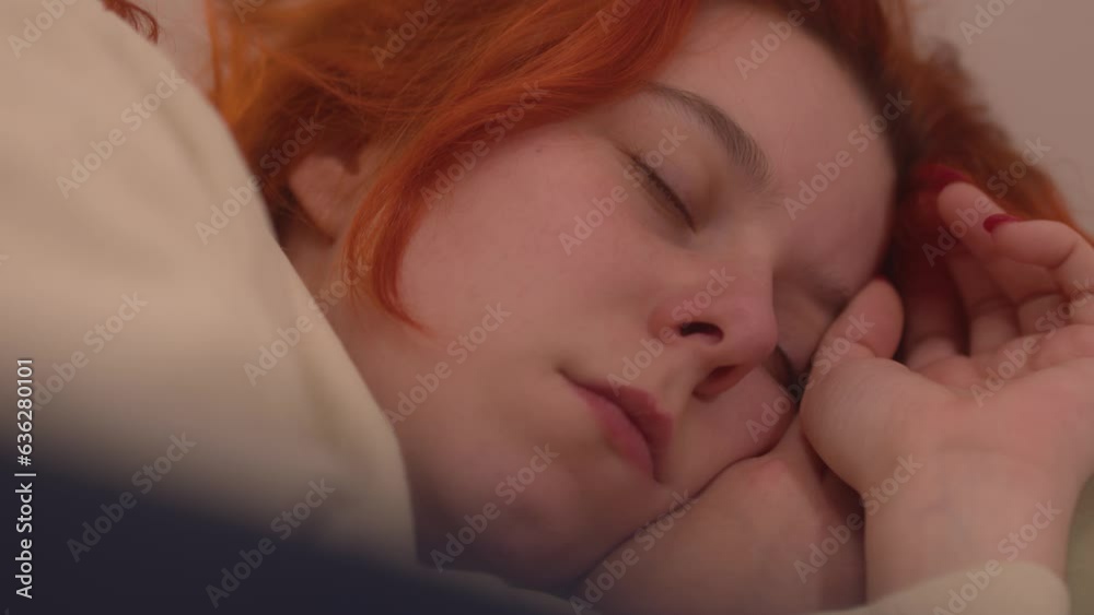 Beautiful ginger woman deep sleeping at night, handheld view