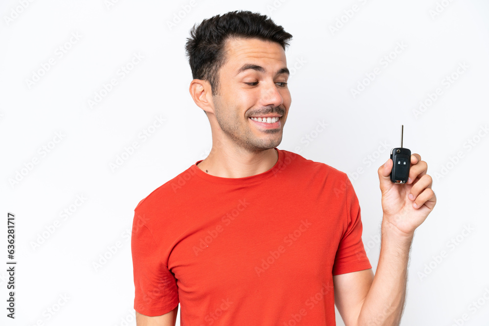 Young handsome man holding car keys over isolated white background with happy expression Young handsome man holding car keys over isolated white background with happy expression