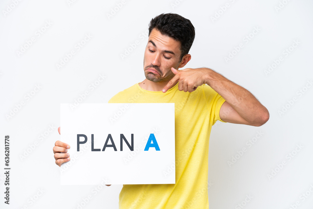 Young handsome man over isolated white background holding a placard with the message PLAN A and pointing it Young handsome man over isolated white background holding a placard with the message PLAN A and pointing it