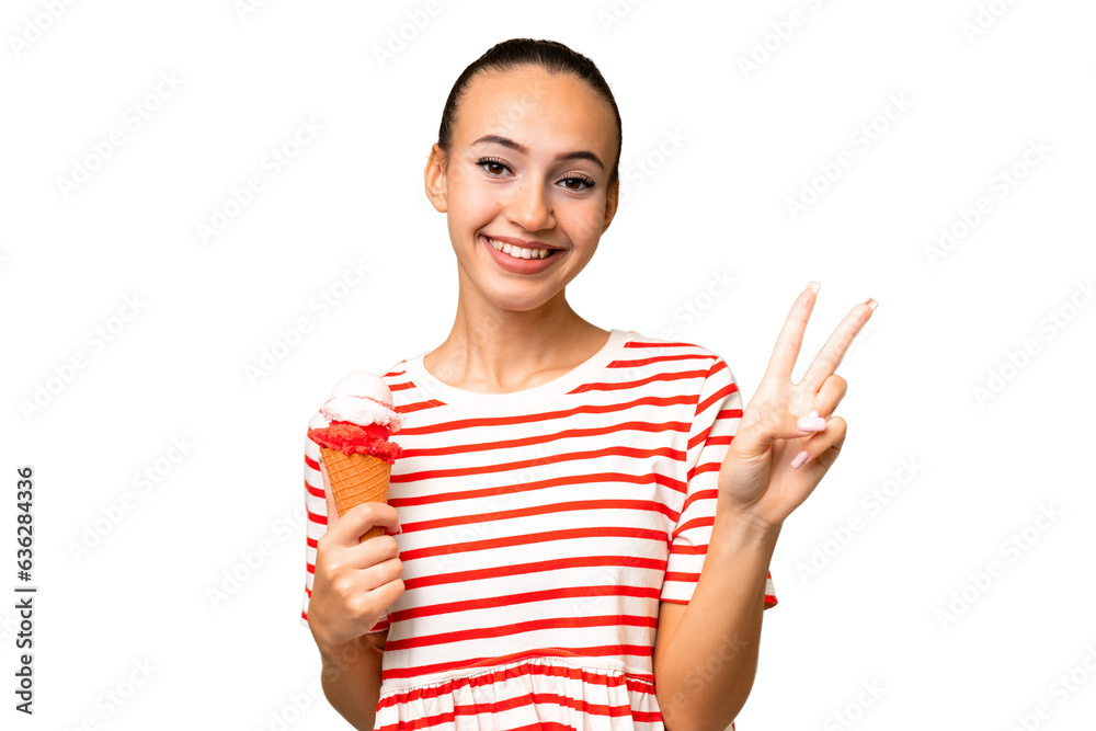 Young Arab woman with a cornet ice cream over isolated background smiling and showing victory sign Young Arab woman with a cornet ice cream over isolated background smiling and showing victory sign