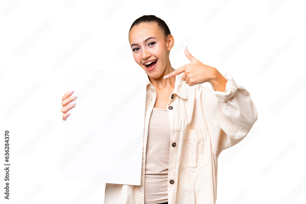 Young Arab woman over isolated background holding an empty placard with happy expression and pointing it Young Arab woman over isolated background holding an empty placard with happy expression and pointing it
