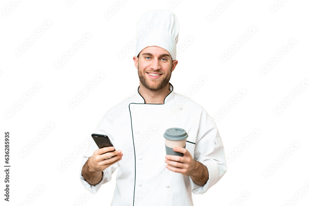 Young blonde man Chef over isolated chroma key background holding coffee to take away and a mobile Young blonde man Chef over isolated chroma key background holding coffee to take away and a mobile