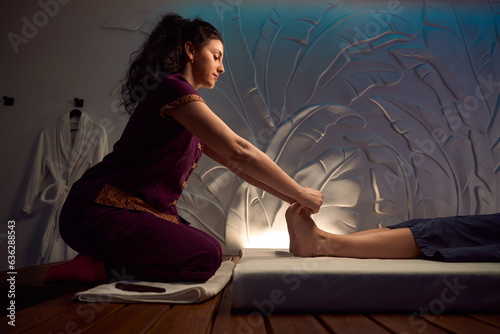 Obraz na plátně Focused masseuse giving Thai feet massage to spa client