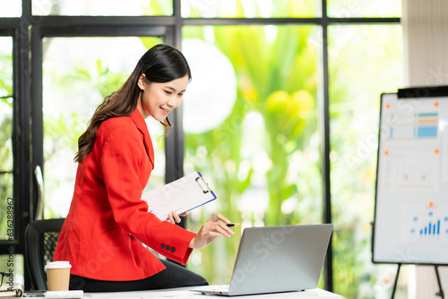 Young Asian businesswoman calculating tax invoice, loan interest rate, law firm, entrepreneur using financial calculator in home office photo