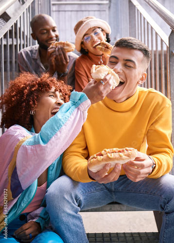 Friends  city and feeding food outdoor for happiness  funny laugh and fun on stairs. Diversity  eating and gen z group of men and women with a hotdog on a date  adventure and freedom in urban town