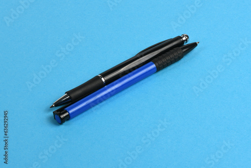 Business blue and black automatic ballpoint pen isolated on blue