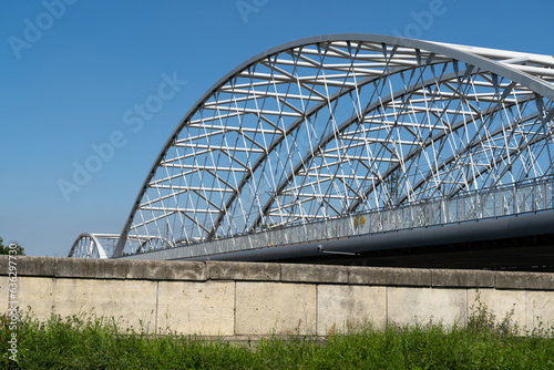 Railway bridge and a pedestrian and bicycle footbridge, connecting Grzegórzki with Zabłocie in Krakow, Poland. Train viaduct and walkway spanning over the Vistula River in Cracow, Wisła Kraków.