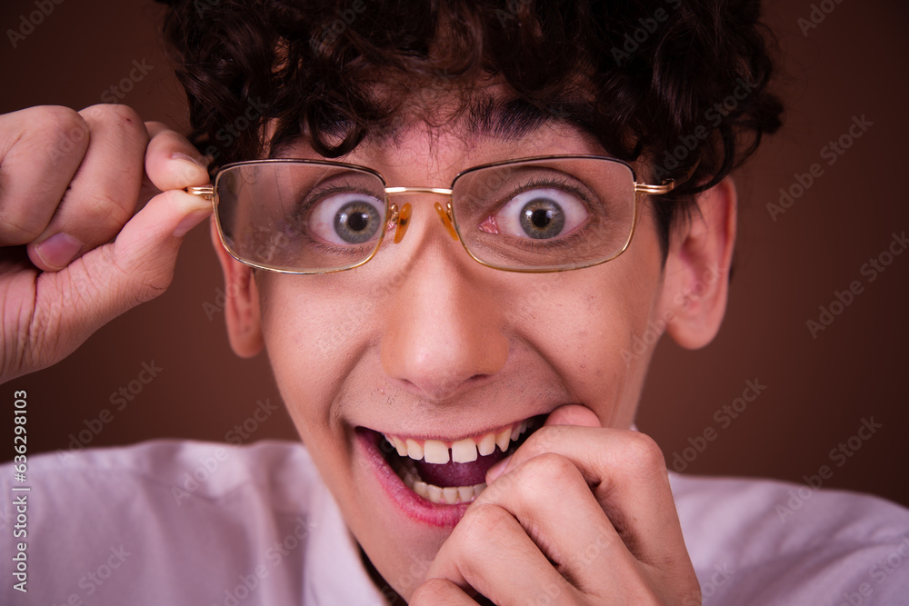 Funny young guy posing in the studio on a brown background. Funny young guy posing in the studio on a brown background.