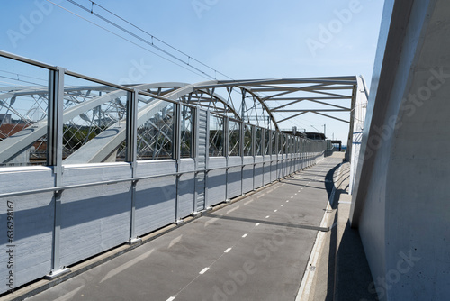 Pedestrian and bicycle footbridge along the railway bridge, connecting Grzegórzki with Zabłocie in Krakow, Poland. Train viaduct and walkway spanning over the Vistula River in Cracow, Wisła Kraków. photo