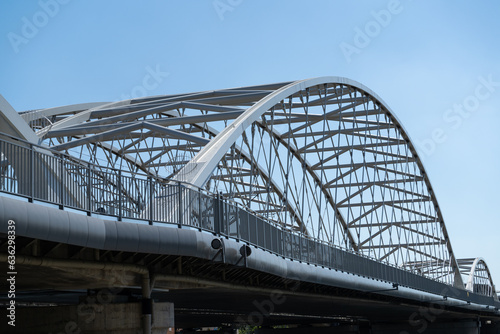 Railway bridge and a pedestrian and bicycle footbridge, connecting Grzegórzki with Zabłocie in Krakow, Poland. Train viaduct and walkway spanning over the Vistula River in Cracow, Wisła Kraków. © Longfin Media