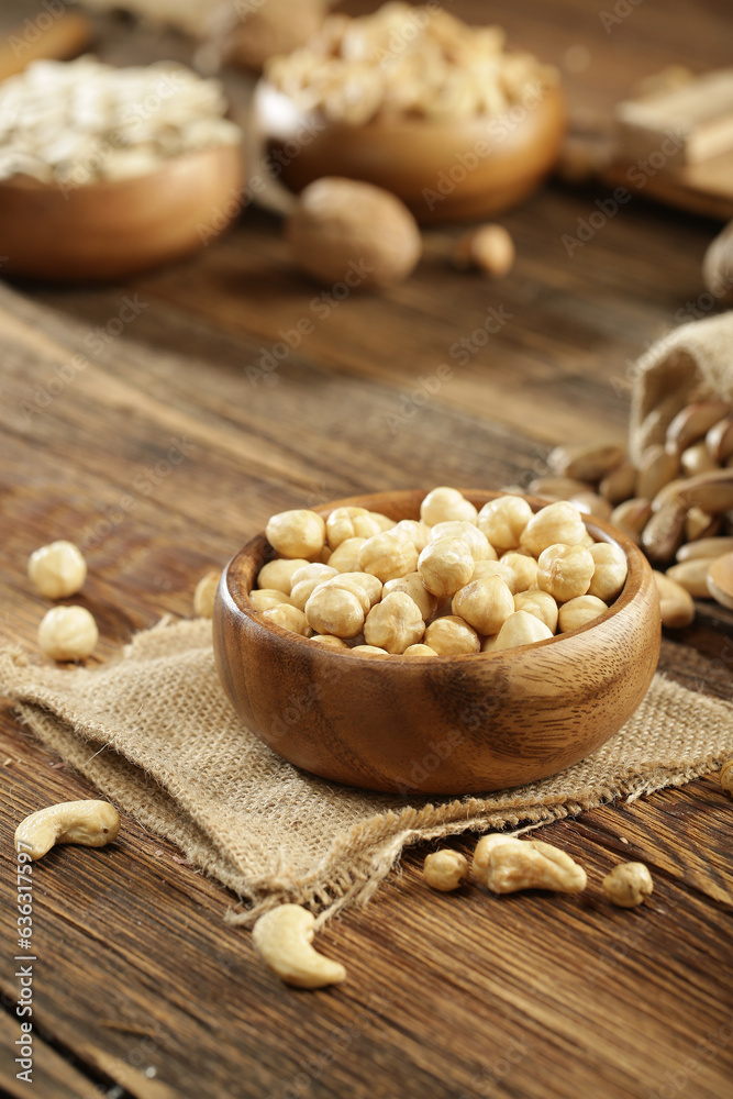 Fototapeta premium DRİED NUTS AND FRUİTS IN WOODEN BOWL ON BROWN FLOOR