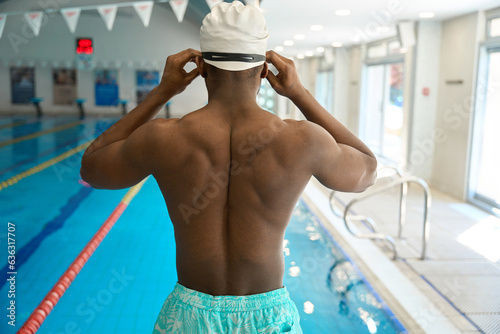 Swimmer putting on protective eyewear before swimming in pool photo