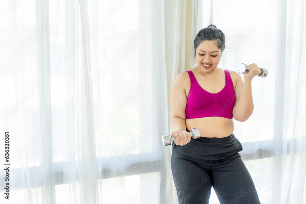 Asian fat women , Fat girl , Chubby, overweight plus size in sports wear attempt exercises with dumbbell lifting at the bedroom - lifestyle Woman diet weight loss overweight problem concept Asian fat women , Fat girl , Chubby, overweight plus size in sports wear attempt exercises with dumbbell lifting at the bedroom - lifestyle Woman diet weight loss overweight problem concept
