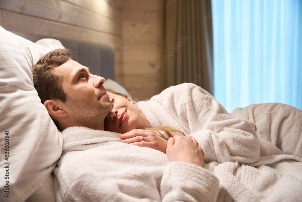 Dreamy lady lying on chest of her beloved man