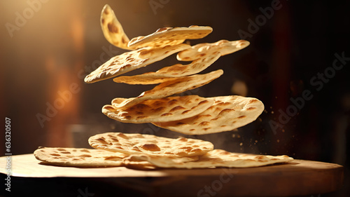 Levitating Indian naan bread on dark background.  photo