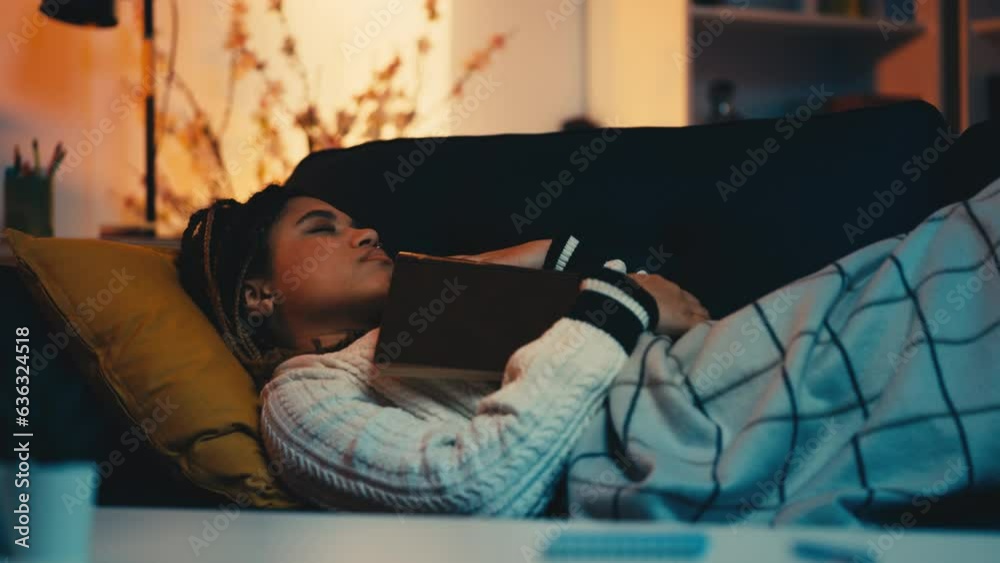 Young African American woman fell asleep while reading a book on sofa, relax Young African American woman fell asleep while reading a book on sofa, relax
