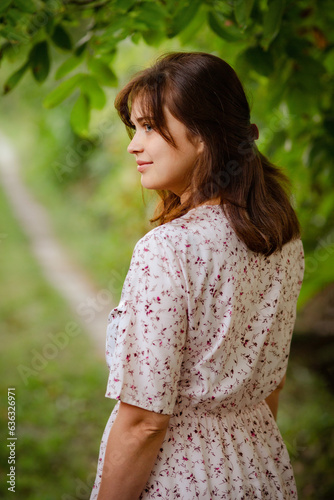 young romantic girl with brown hair near green path, woman walking on nature, natural female beauty
