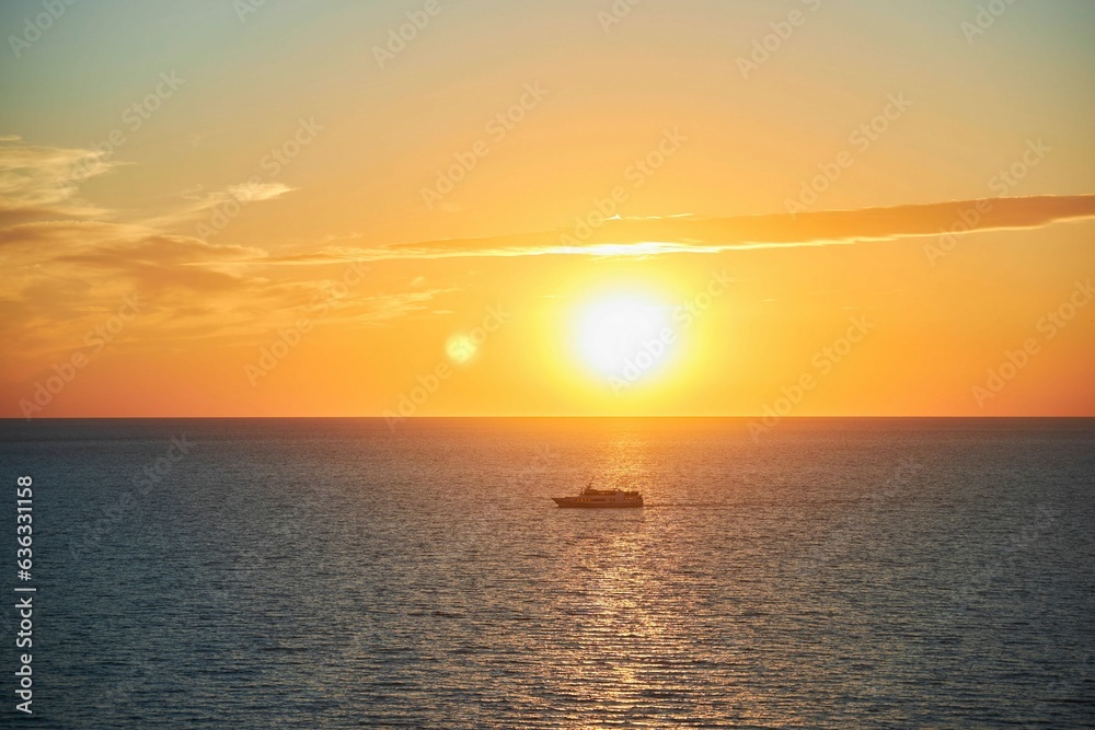 Beautiful landscape with sunset in the sea and a yacht