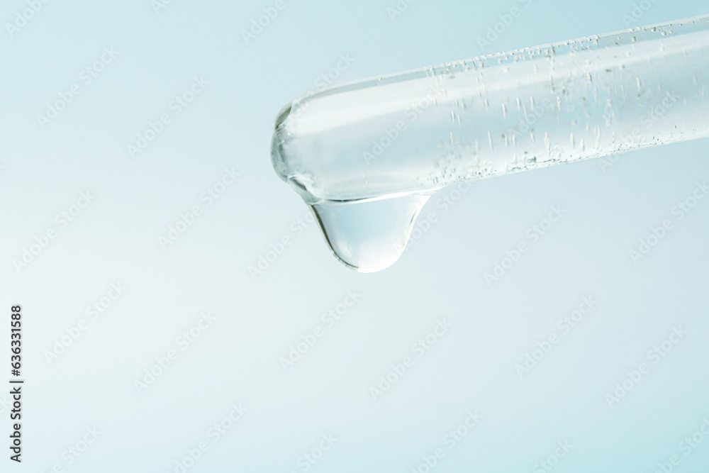 Pipette dropping liquid into glass tubes. Laboratory glassware with dropper into test tube close up macro. laboratory equipment glassware. Concept of medical or science laboratory. blue background. Pipette dropping liquid into glass tubes. Laboratory glassware with dropper into test tube close up macro. laboratory equipment glassware. Concept of medical or science laboratory. blue background.