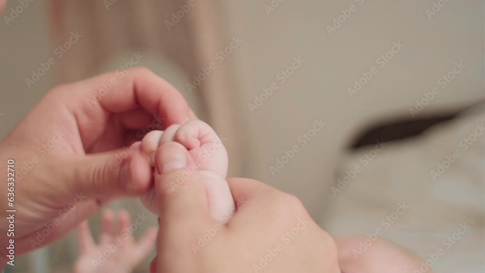 Selective focus of unrecognizable caring young mom massaging baby arm, palm and finger, lying on comfy bed at home. Children massage and care of doctor female. Concept of prophylaxis and soothing Selective focus of unrecognizable caring young mom massaging baby arm, palm and finger, lying on comfy bed at home. Children massage and care of doctor female. Concept of prophylaxis and soothing