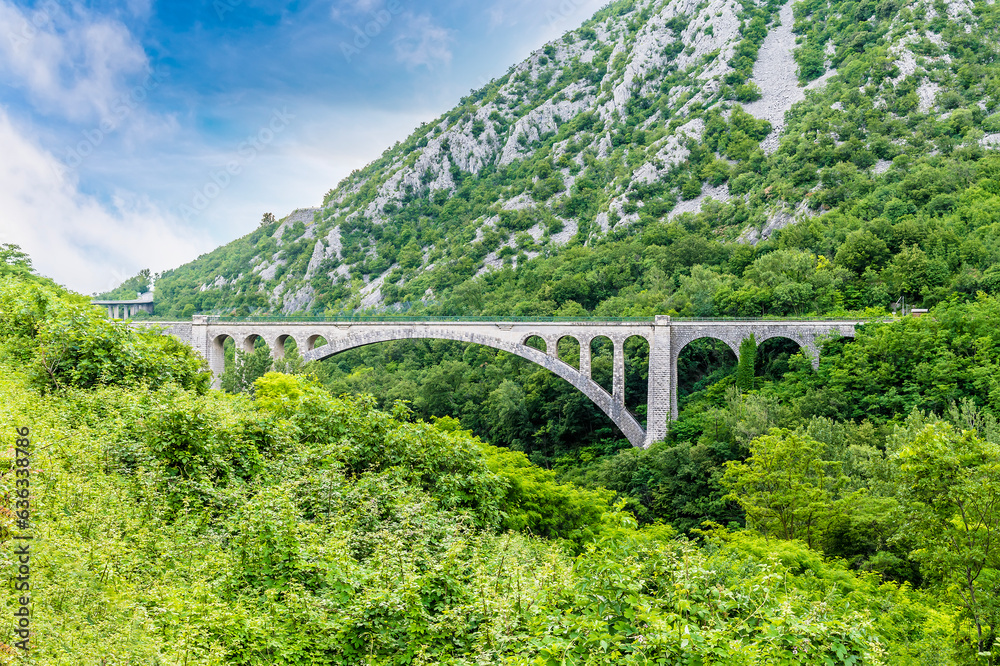 A view towards the largest stone arch railway bridge at Solkan in Slovenia in summertime A view towards the largest stone arch railway bridge at Solkan in Slovenia in summertime