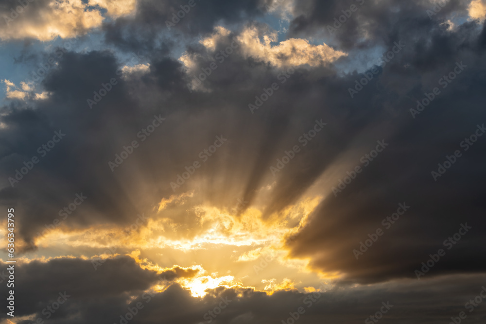 Rays of light against the background of clouds in the spring sky
