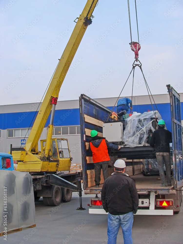 Contractor Loading Loading on cargo transport using crane, industrial refrigeration ...