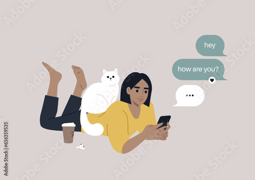 A youthful character reclining on their stomach, engrossed in checking their mobile phone's messenger app, meanwhile, a cat perches on their back, seeking attention
