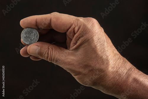 Hand holding a quarter dollar coin - personal finance, savings and investment concept.
