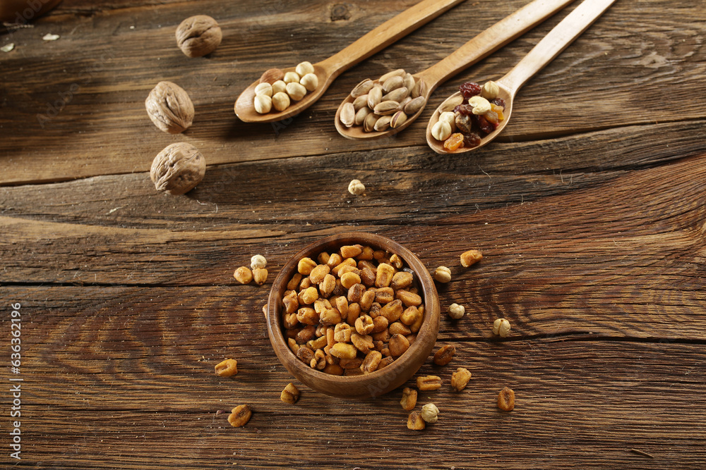 DRİED NUTS AND FRUİTS IN WOODEN BOWL ON BROWN FLOOR DRİED NUTS AND FRUİTS IN WOODEN BOWL ON BROWN FLOOR