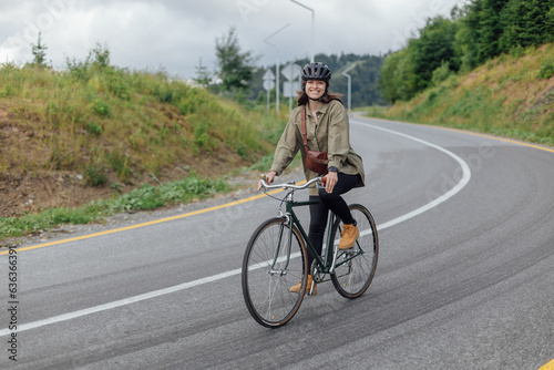 Woman cyclist ride vintage gravel bikel on road path. Bicycle road infrastructure