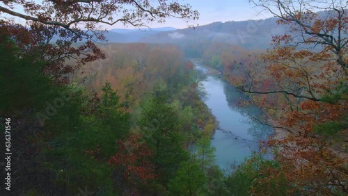 Drone arial view of autumn river in the ozark mountains of Arkansas with fall colored forest during early morning  