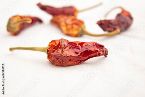 Dry red hot pepper lies on a white tablecloth. The concept of cooking, spicy food.