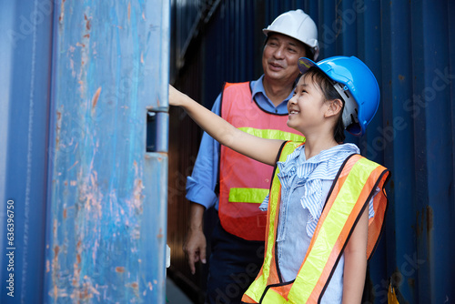 engineer or factory worker with her niece pointing to containers in warehouse storage