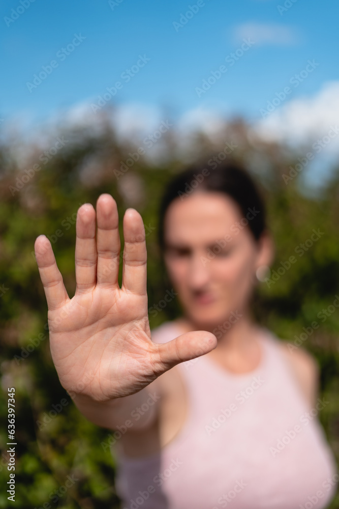 firm woman expressing the action of enough with her hand, no or stop, no violence, no permission, no, it is no