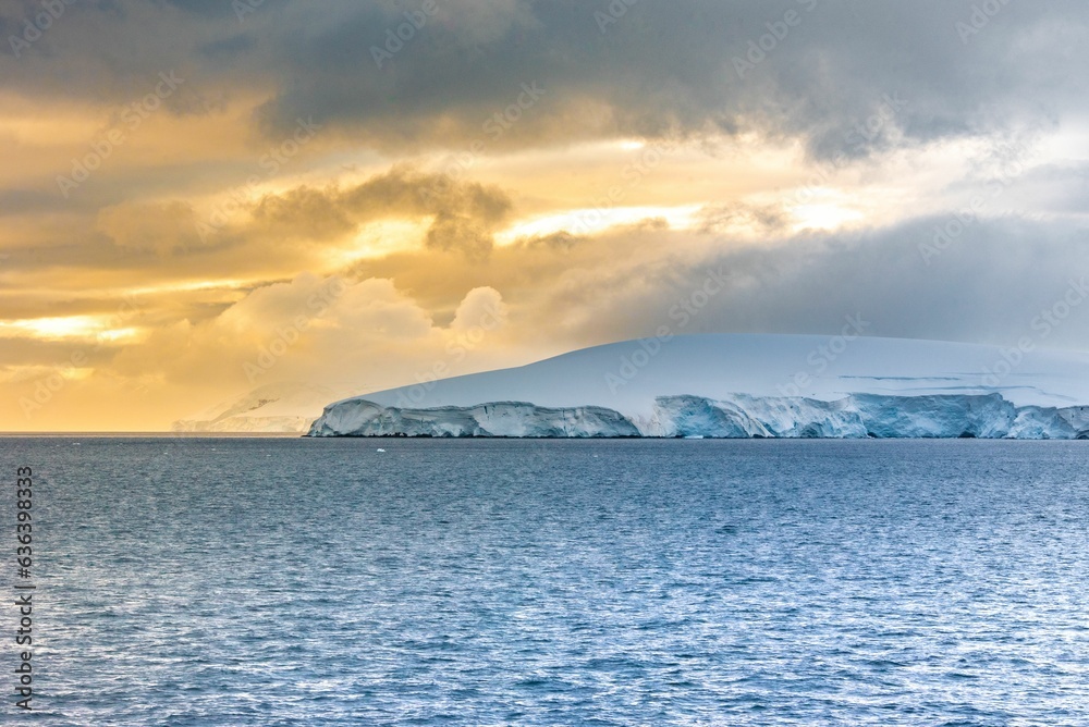 Stunning winter landscape of a mountain in 
ocean, covered in a blanket of fresh snow in Antarctica