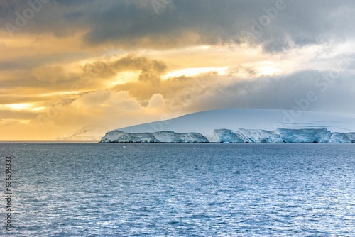 Stunning winter landscape of a mountain in ocean, covered in a blanket of fresh snow in Antarctica