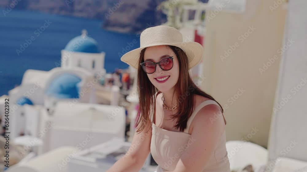 A beautiful tourist woman enjoying view at the blue domed church of the village of Oia, Santorini, Greece, during her summer holidays
A beautiful tourist woman enjoying view at the blue domed church of the village of Oia, Santorini, Greece, during her summer holidays